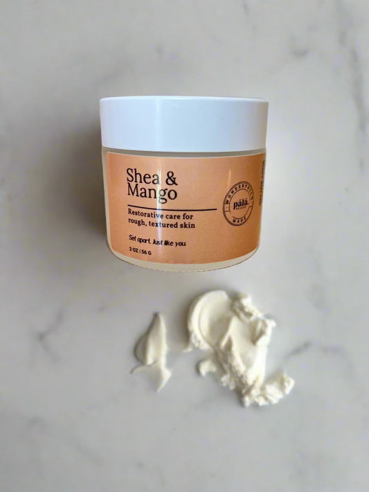 Jar of Shea & Mango product on a beige surface with a white background